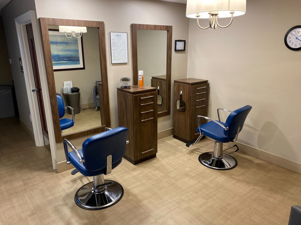 A modern hair salon with two styling chairs and mirrors.