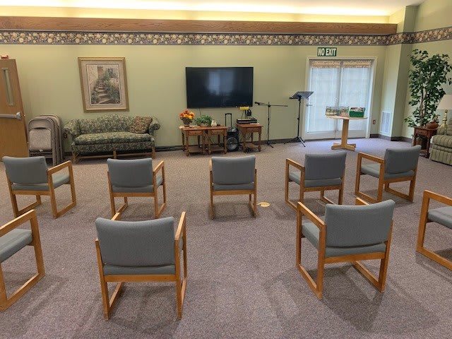A seating area with arranged chairs facing a television.