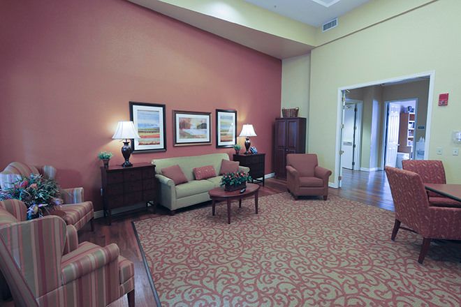 A cozy living room with a sofa, armchairs, and decorative artwork.