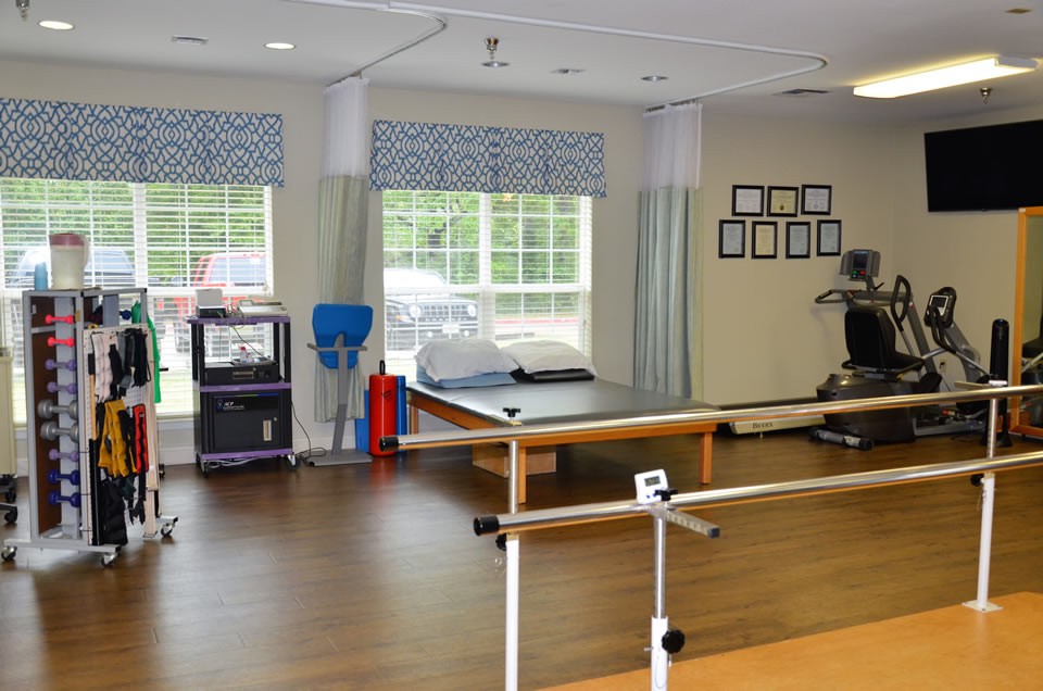 A modern physical therapy room equipped with various exercise and rehabilitation tools.