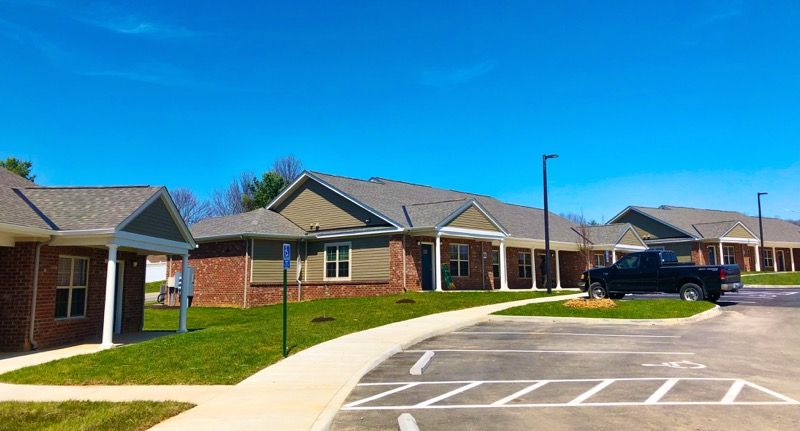 A healthcare clinic with a parking lot under a clear blue sky.