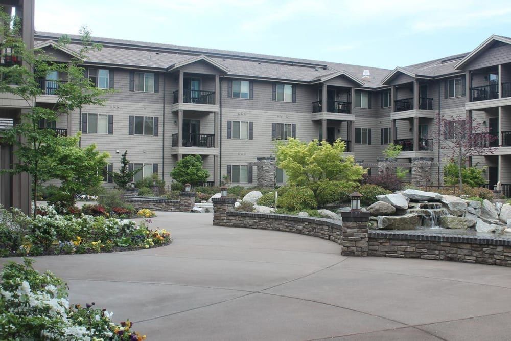 A well-maintained apartment building with beautiful landscaping and garden features.