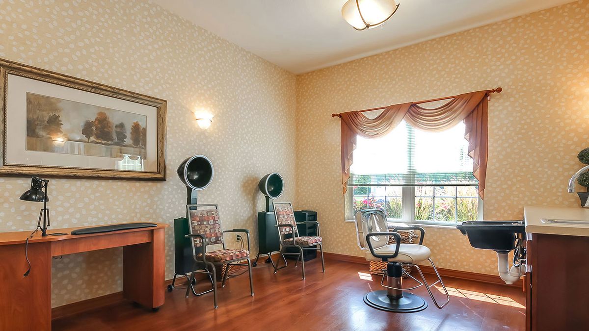 A cozy hair salon room with vintage dryer chairs and warm decor.