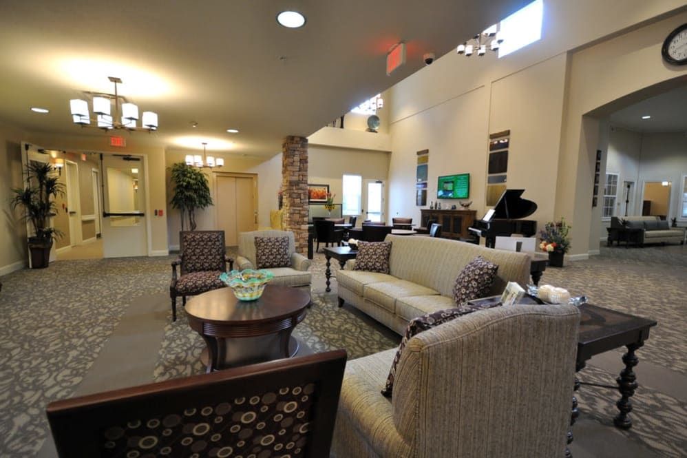 A spacious and well-furnished living room with comfortable seating and a grand piano.
