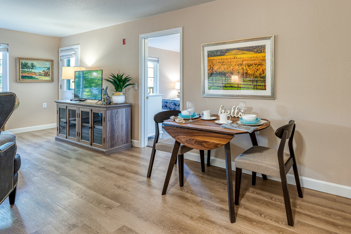 A modern, well-lit dining area with stylish furniture and art on the wall.