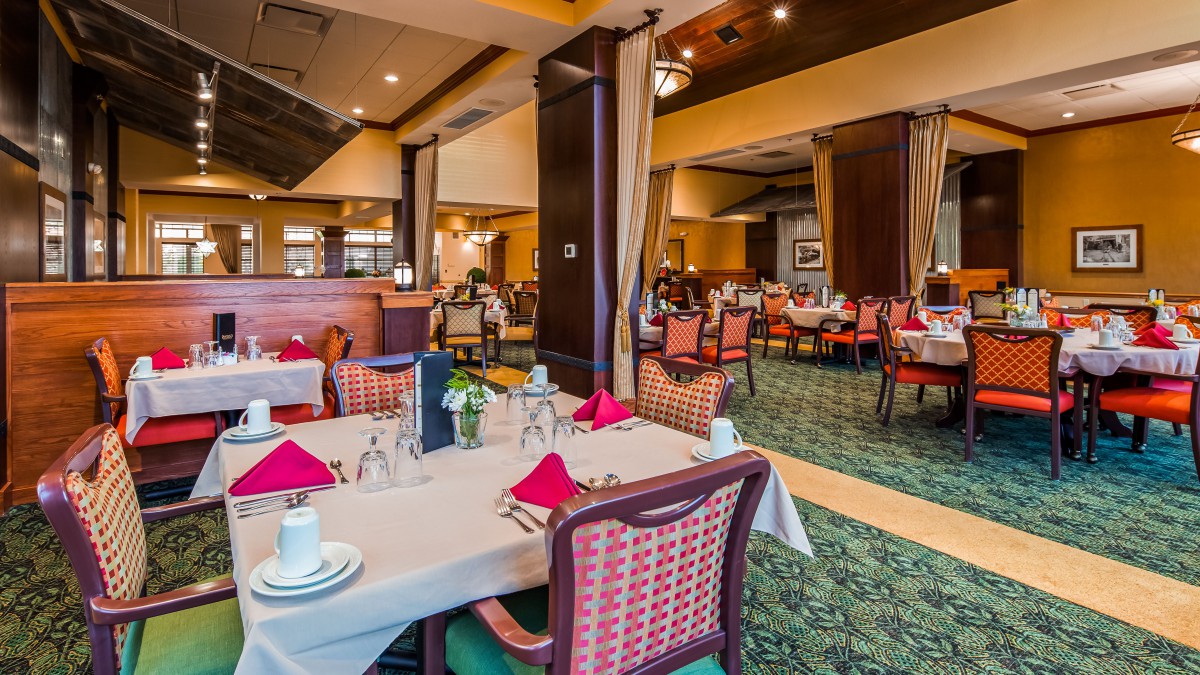 An elegant restaurant dining area with neatly arranged tables and chairs, set for guests.