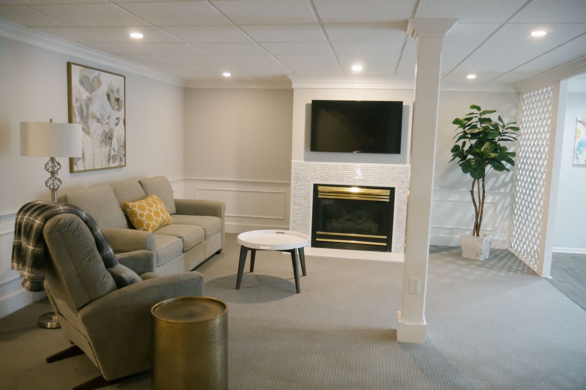 A cozy and modern living room featuring a comfortable sofa, wall-mounted television, and a fireplace.