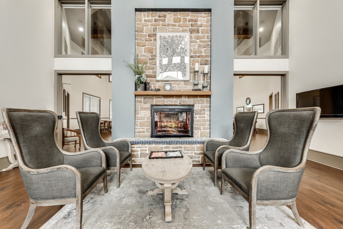 A modern living room with a cozy fireplace and elegant armchairs.