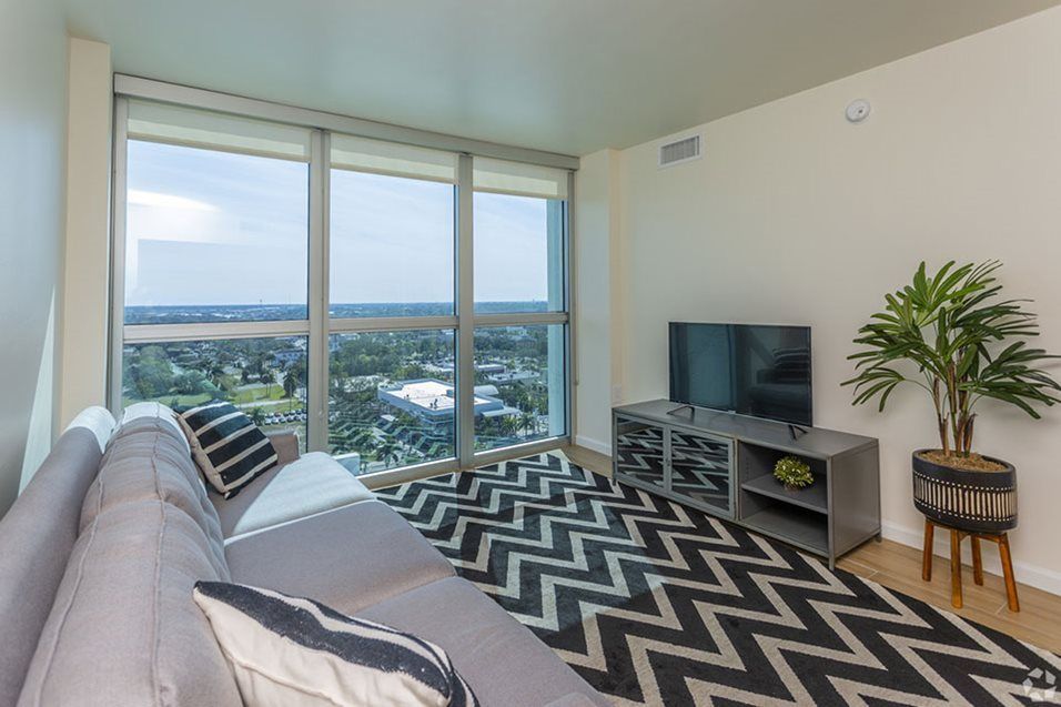 A modern living room with large windows offering a scenic city view.
