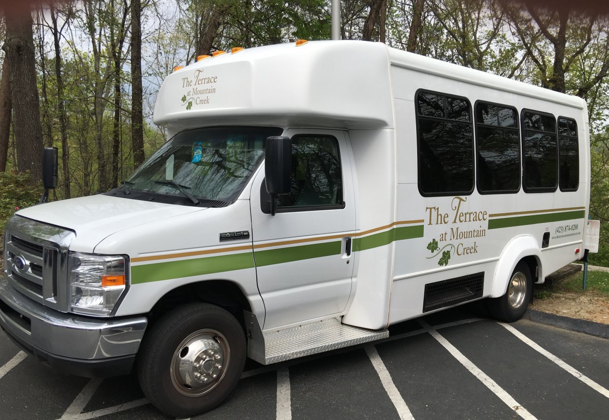 A shuttle bus parked in a parking lot.