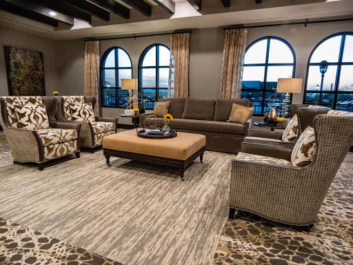 A cozy living room with elegant furniture and large arched windows.