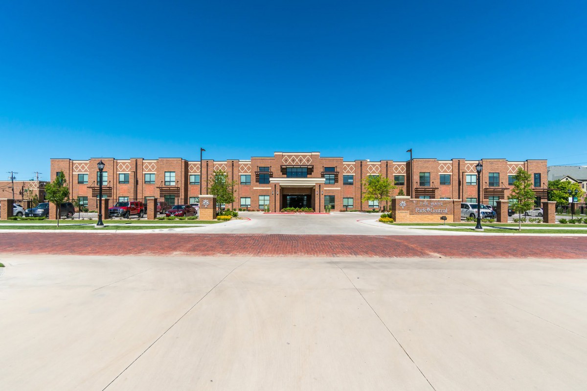 A modern brick school building under a clear blue sky.