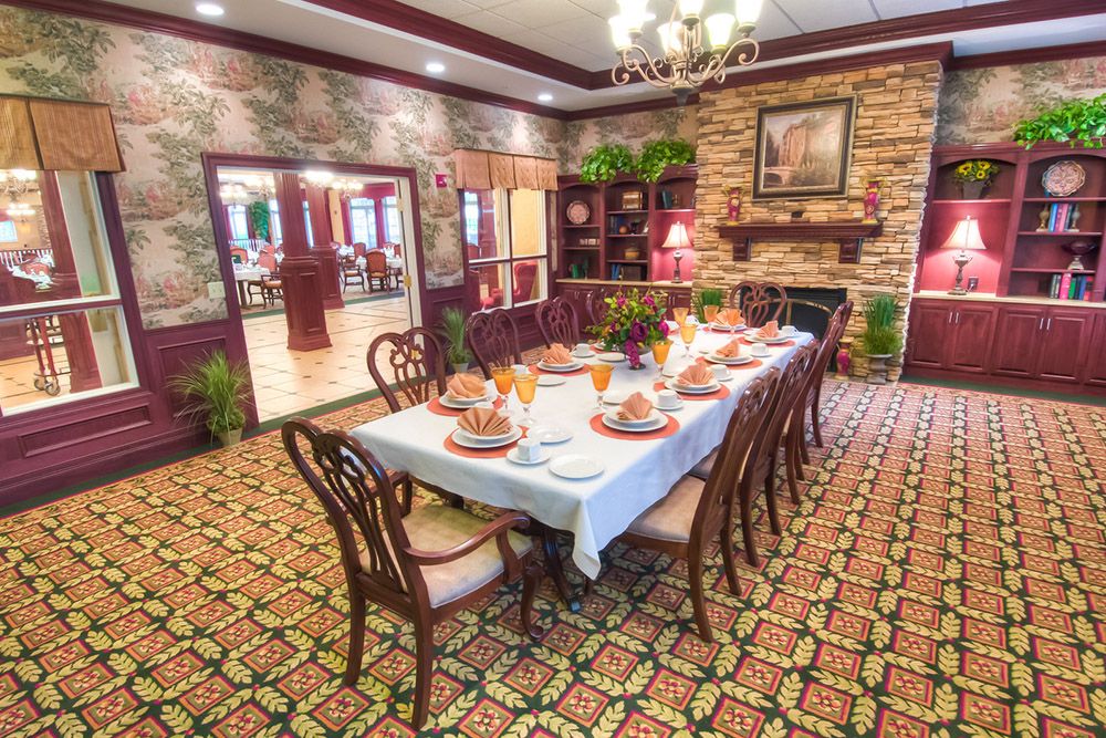 A beautifully set dining table in an elegantly decorated room with a fireplace.