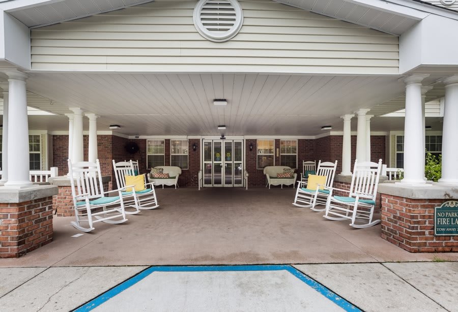 A welcoming front porch with rocking chairs at the entrance of a building.
