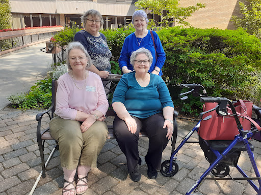 A joyful gathering of four women enjoying a sunny day outdoors.