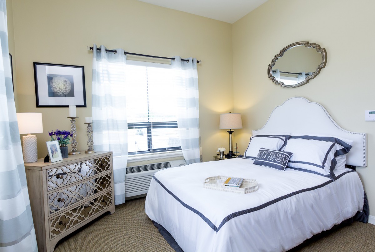 Brightly lit bedroom with elegant decor and a cozy bed.