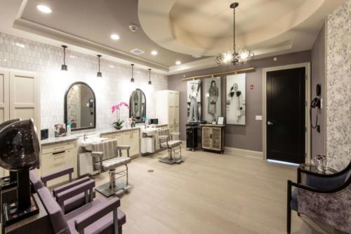 A modern salon interior with stylish chairs and mirrored hair stations.