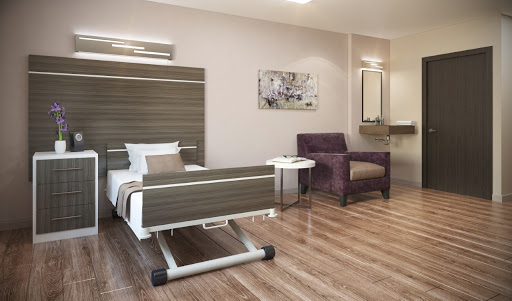 A contemporary patient room featuring a hospital bed, a comfortable chair, and modern decor.