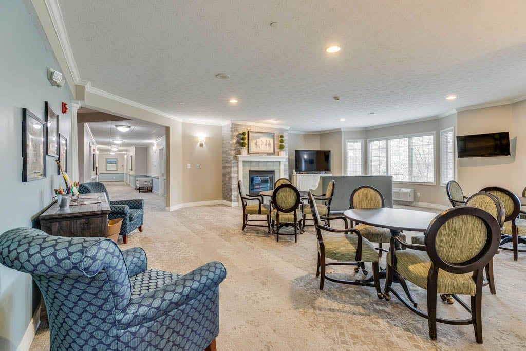 Spacious and elegantly furnished living room with a central fireplace and ample seating.