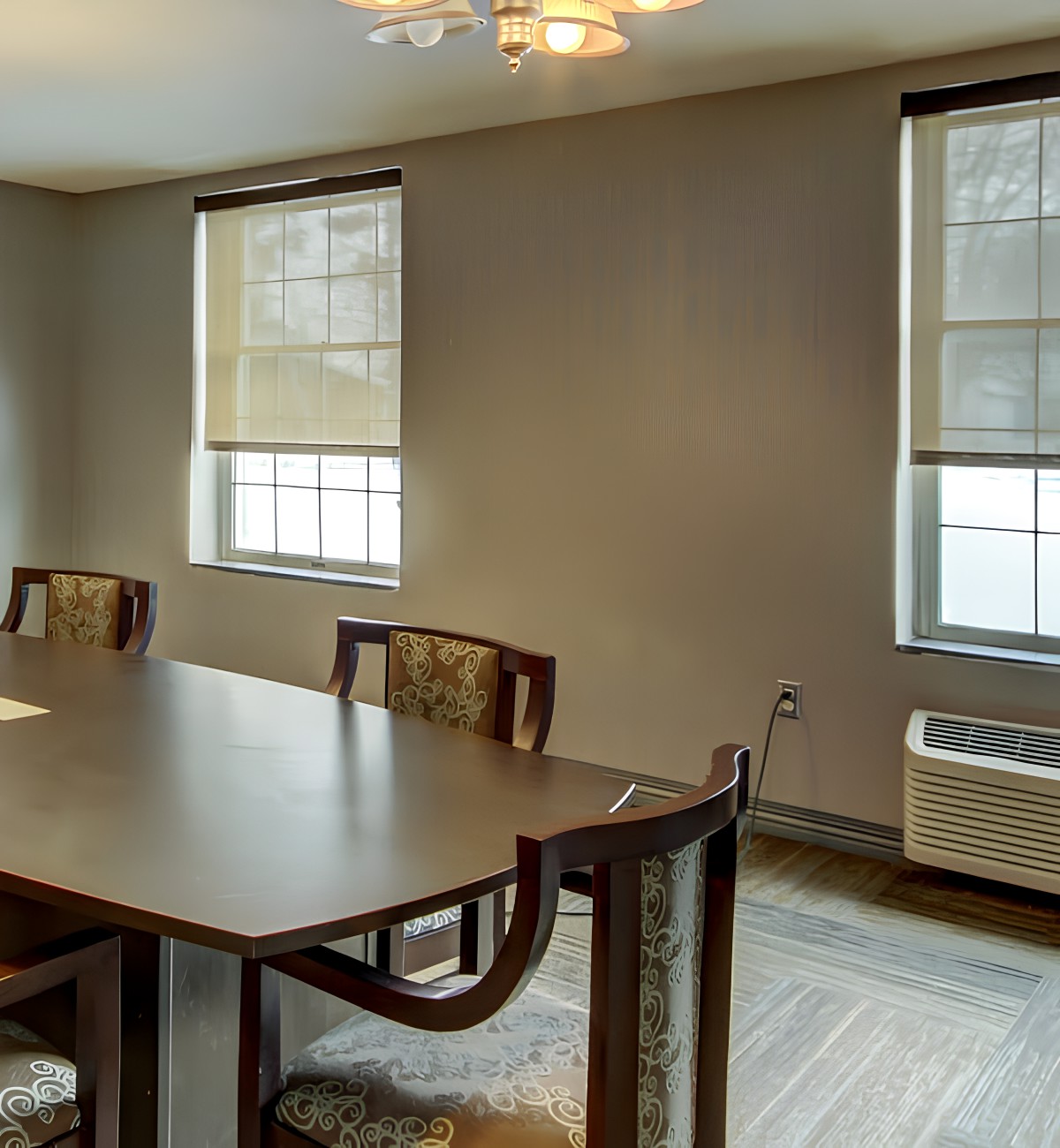 A well-lit conference room with a large table and chairs.