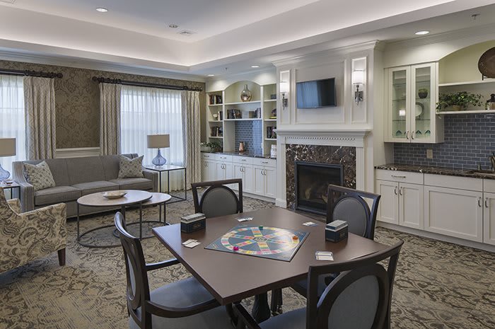 Cozy living room with a fireplace and a table set for games.