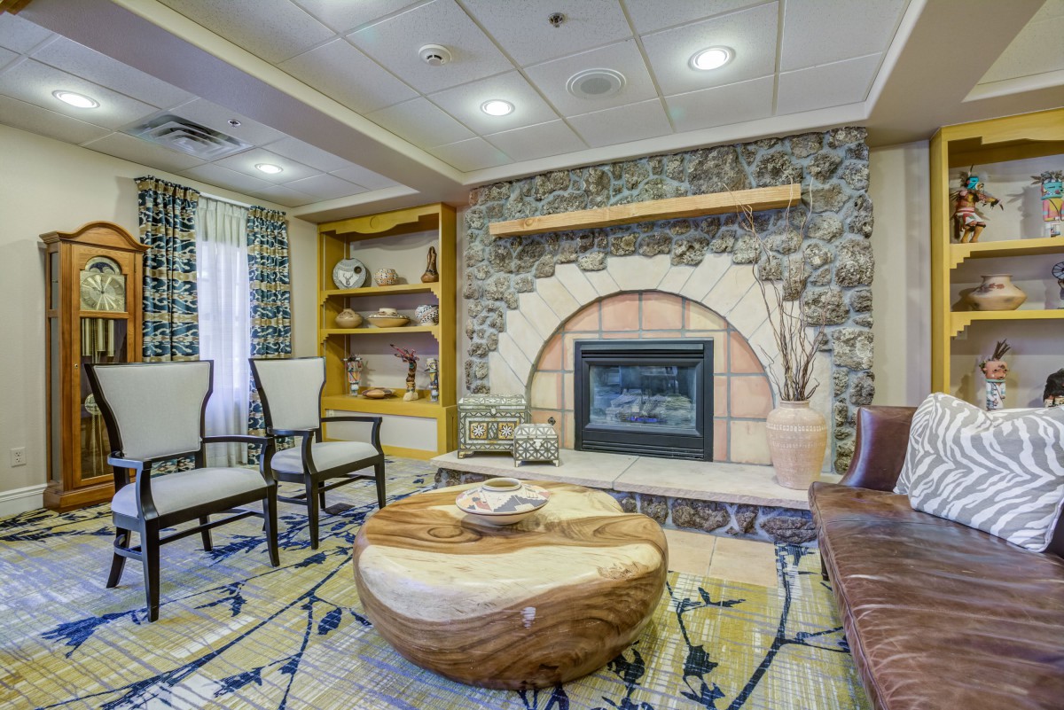 A cozy living room with a rustic fireplace and elegant seating arrangement.
