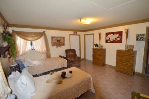 A cozy bedroom with two beds, an armchair, and elegant decor.