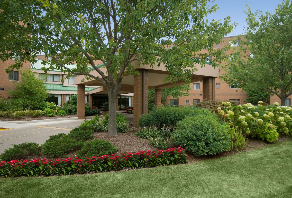 A well-maintained building entrance surrounded by lush greenery and vibrant landscaping.