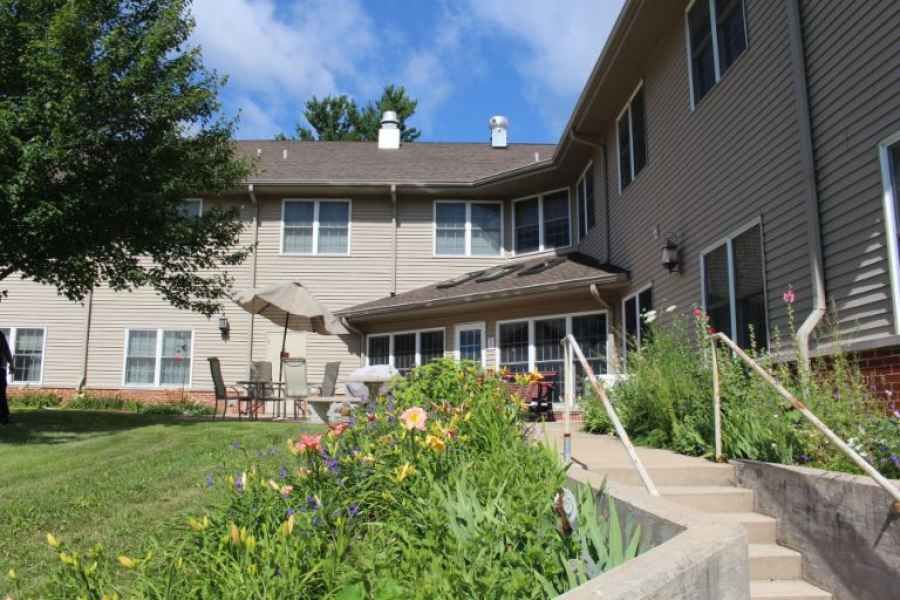 A two-story house with a patio and a landscaped garden in the backyard.