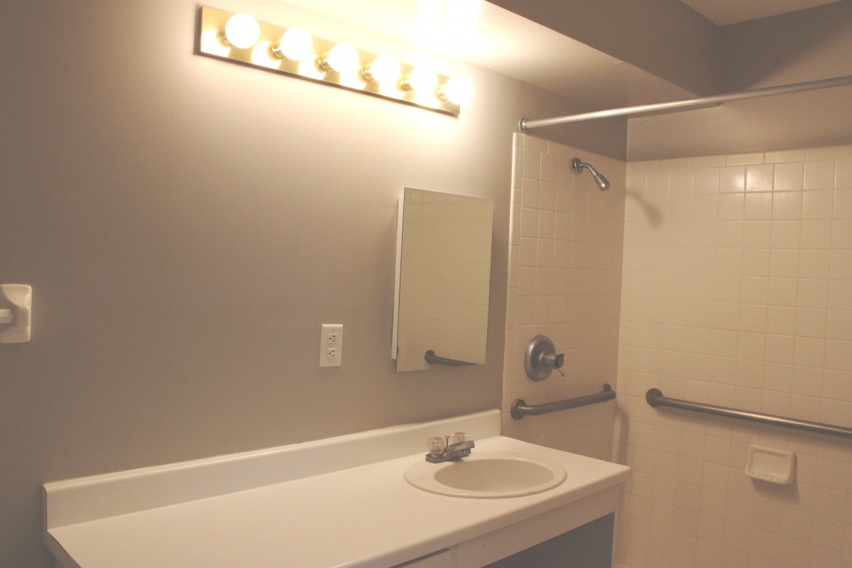 A well-lit bathroom with a mirror and sink.