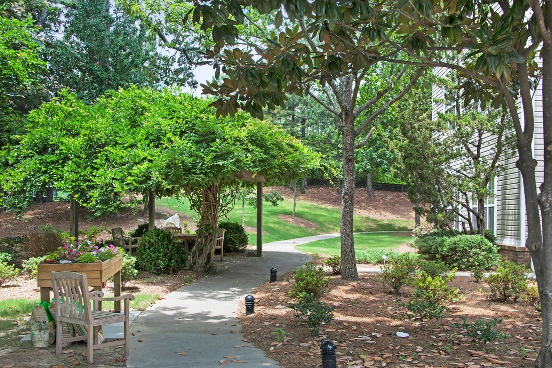 A serene garden pathway with benches and lush greenery.