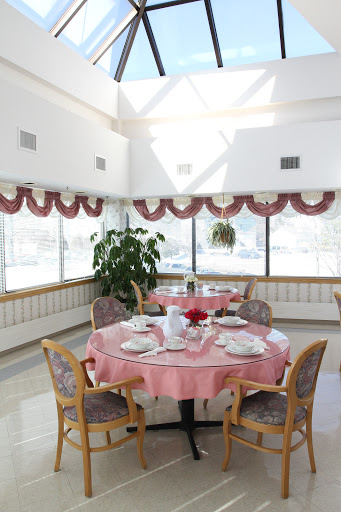 A bright and inviting dining room with elegantly set tables and large windows.