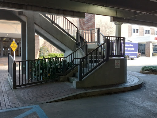 A view of a staircase located inside a parking garage, featuring multiple levels and decorative railings.
