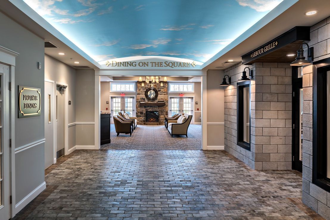 A spacious lobby with a painted sky ceiling, elegant chandelier, and comfortable seating area.