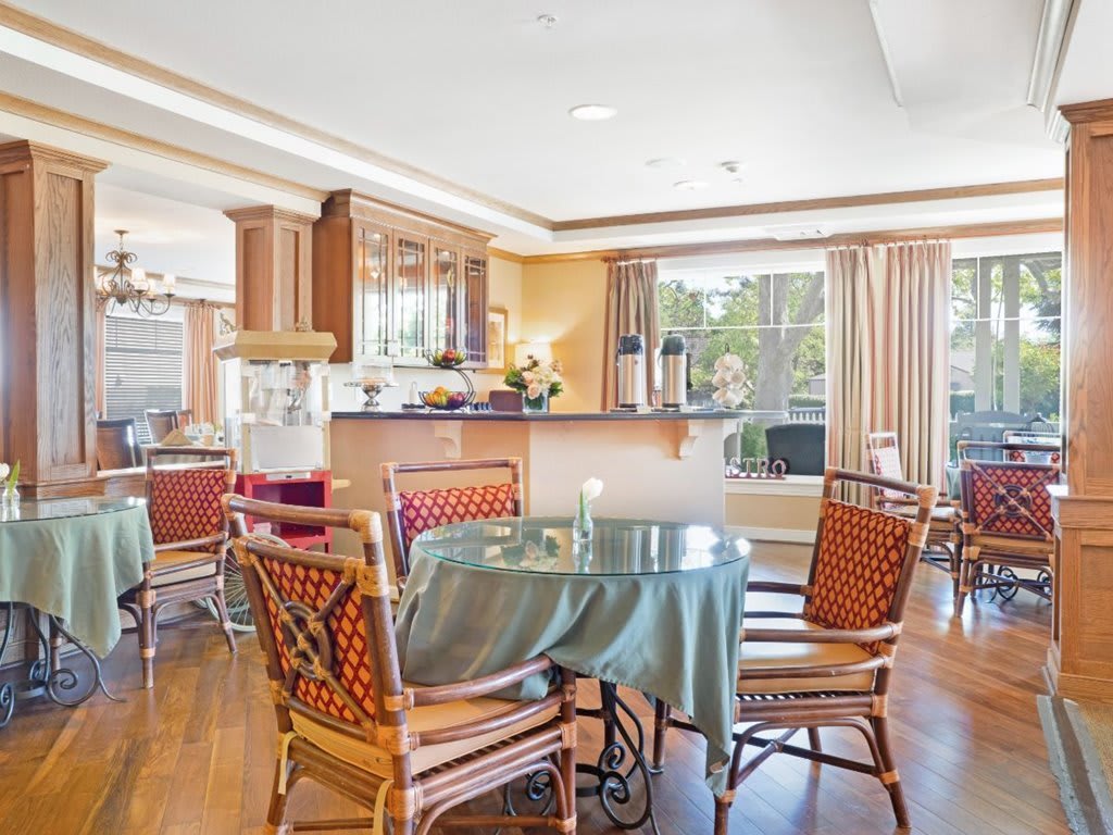 A bright and spacious kitchen and dining area with elegant furnishings and large windows.