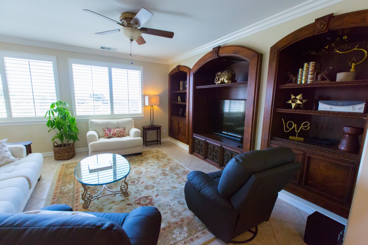 A cozy living room with comfortable seating, built-in bookshelves, and a TV.
