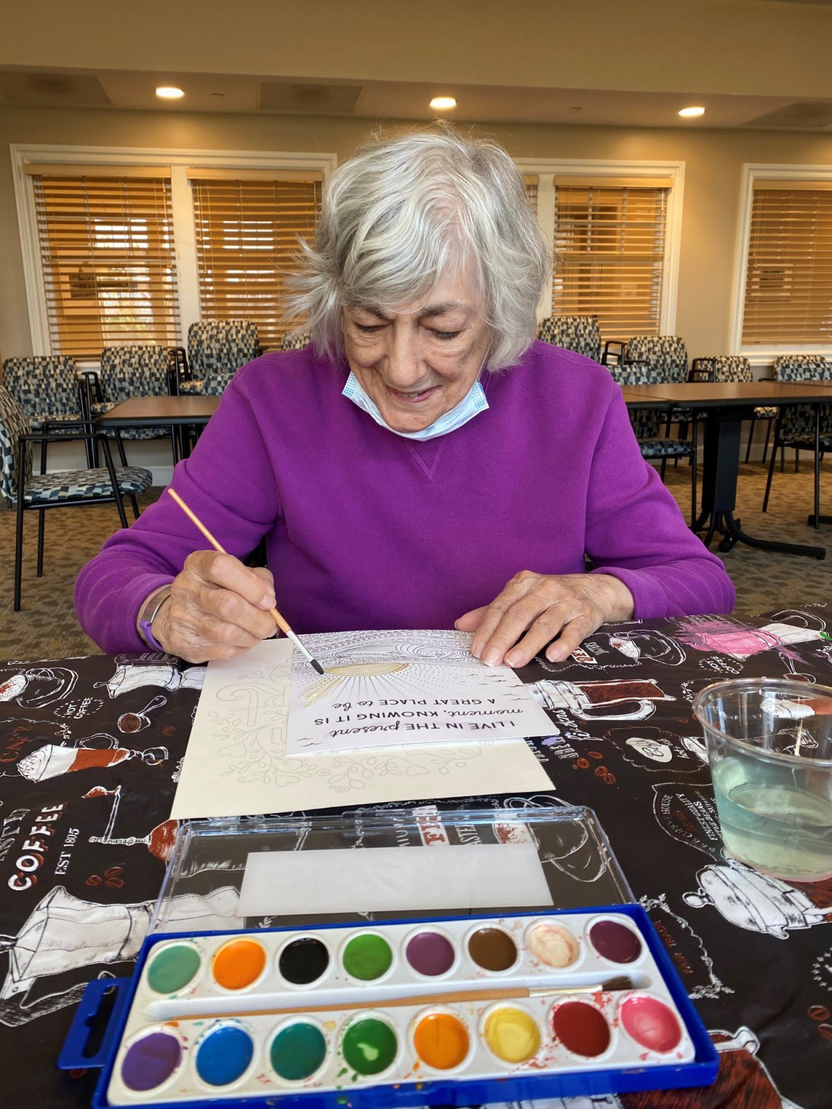 A woman enjoying a watercolor painting session indoors.