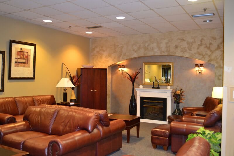 A cozy living room with leather furniture and a fireplace.