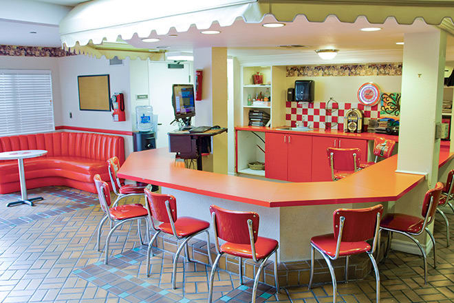 A retro-style diner with red chairs and a counter for seating.