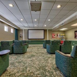 A cozy theater room with comfortable seating and a large projector screen.