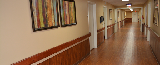 A well-lit hallway featuring decorative artwork and wooden paneling.