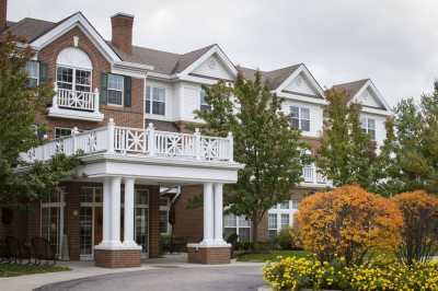 A suburban residential building surrounded by trees and landscaping.