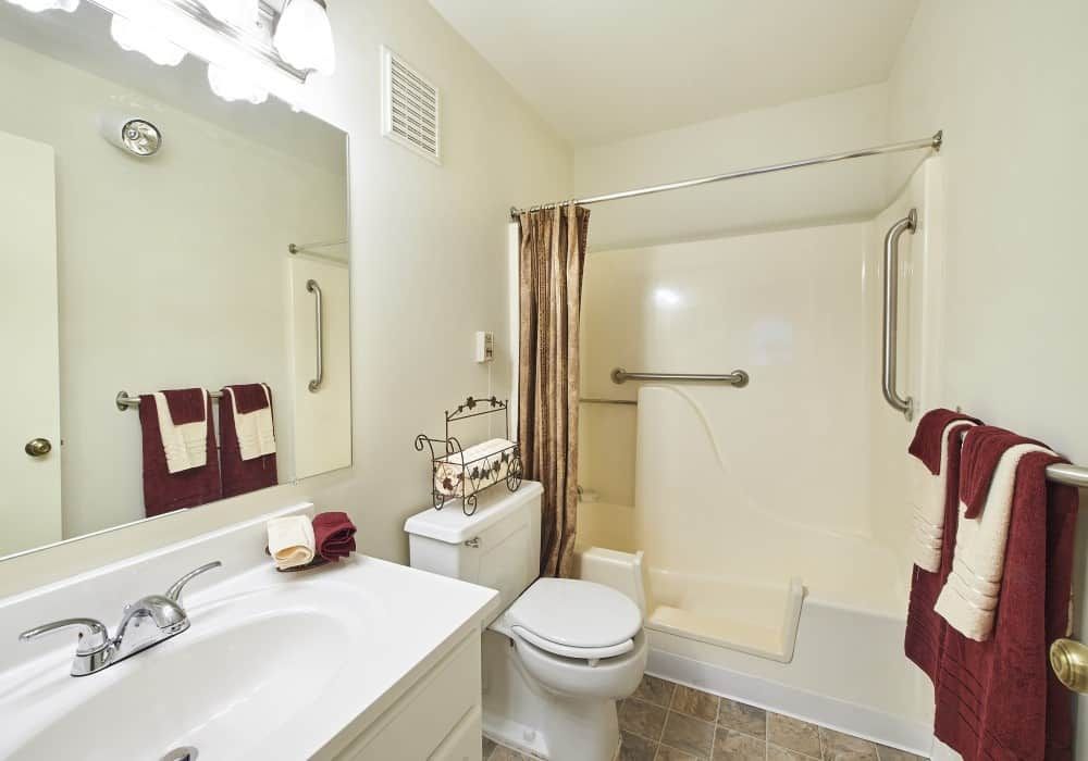 A clean and well-organized bathroom featuring a sink, toilet, and shower area.