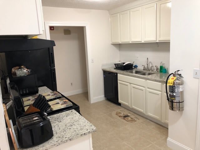 A modern kitchen with white cabinetry and appliances.