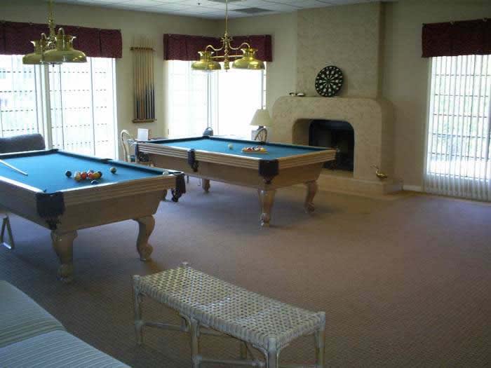 A recreational room featuring pool tables and a dartboard.