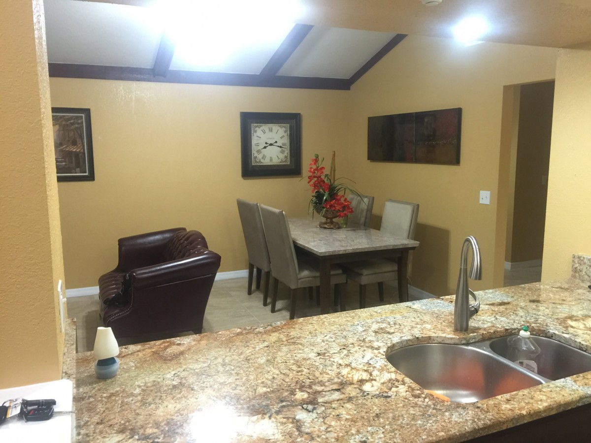 A modern kitchen and dining area with granite countertops and stylish decor.