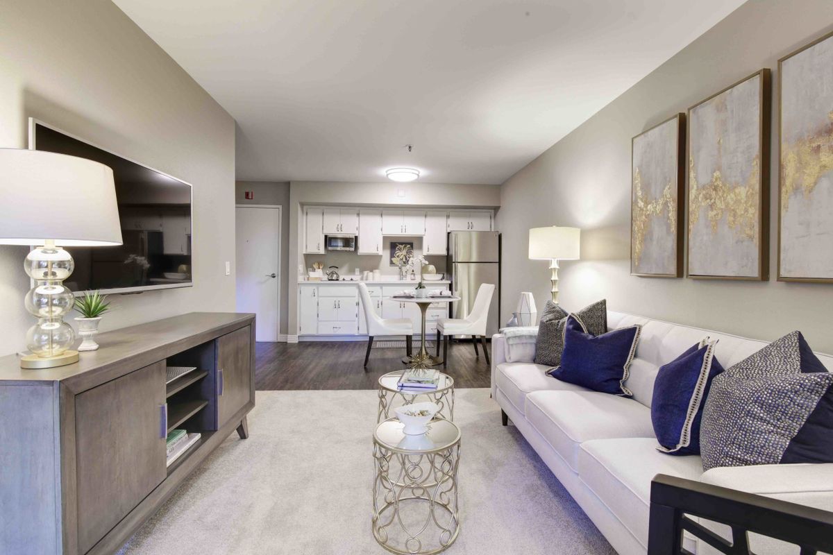 A modern and elegantly furnished living room with an open layout that includes a dining area.