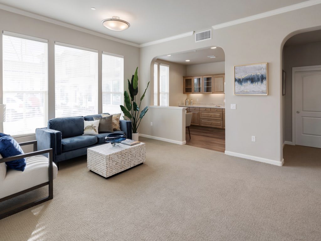 A modern living room with a comfortable sofa, coffee table, and large windows letting in natural light.