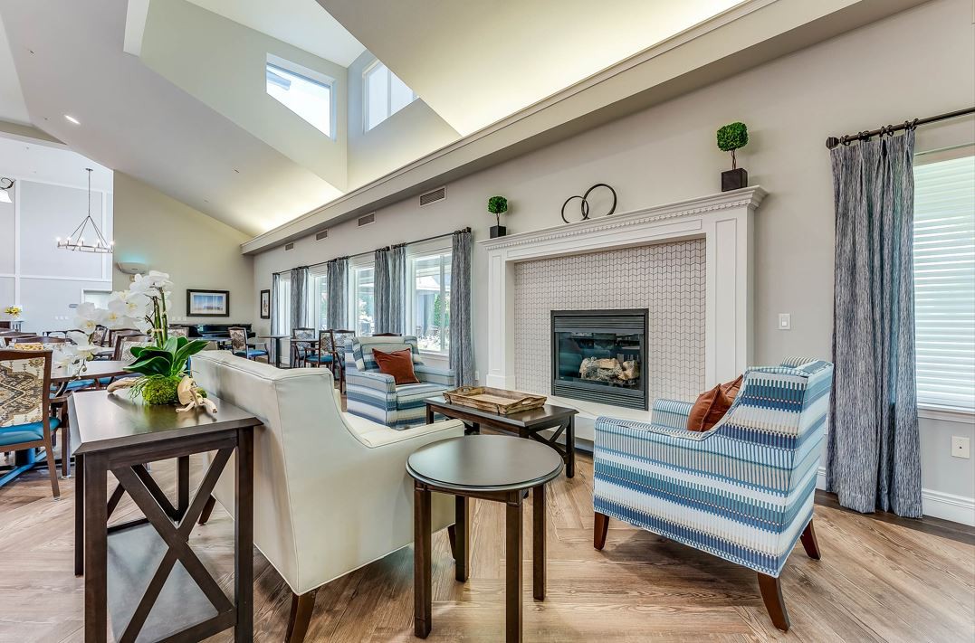 A modern living room with skylights, featuring a fireplace and comfortable seating.