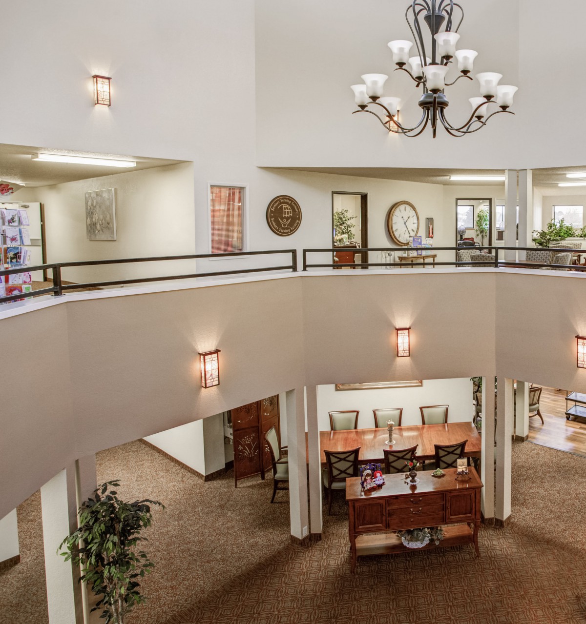 Spacious lobby with a chandelier and upper balcony overlooking the reception area.